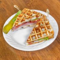 The Woolworth Club Sandwich · Heavenly waffle, ham, bacon, turkey, Swiss and cheddar cheese, lettuce, tomato, and honey mu...
