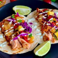 Grilled Salmon Tacos · ( 3)Grilled salmon,  red cabbage,  pineaple avocado salsa , topped with cilantro crema