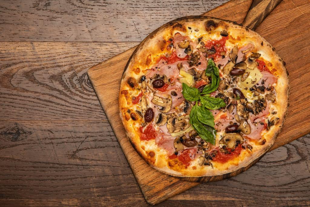 Capricciosa · Tomato, mozzarella, mushrooms, ham, olives and artichoke.