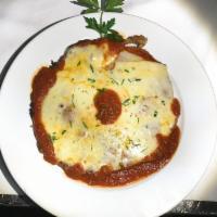 Pollo Parmigiana · Breaded chicken breast with tomato sauce and mozzarella. served over linguine