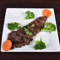 Skirt Steak · Served with rice and beans or moro or tostones and a  green salad