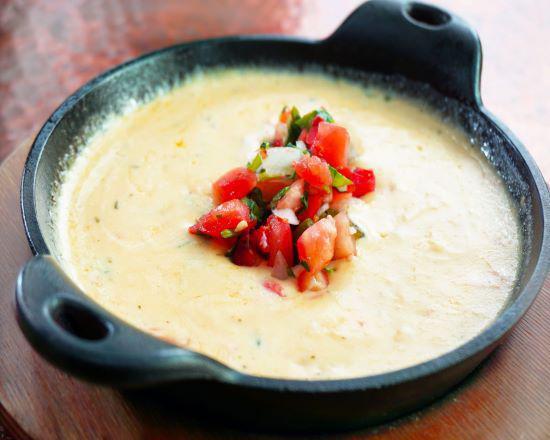 Fiesta Queso Dip · Tex-mex cheese dip with tomatoes, onions, jalapenos and cilantro. *Add chorizo for $1