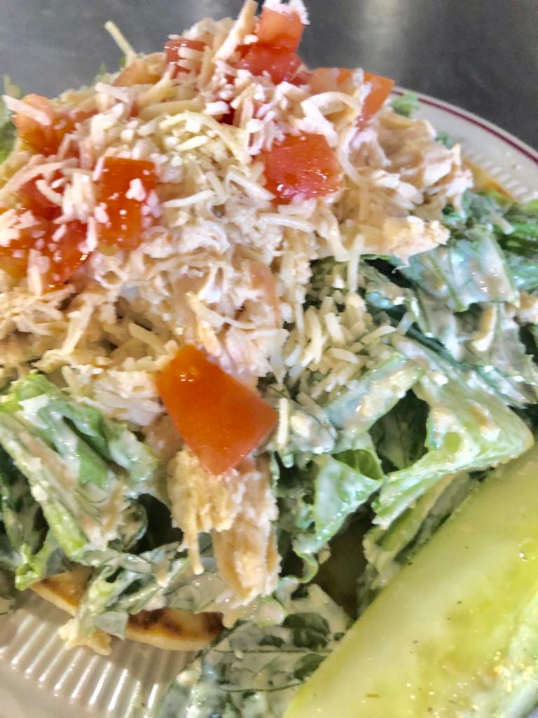 Julie's Caesar Salad · Romaine lettuce tossed in Caesar dressing with Asiago cheese, tomato, green pepper and pesto chicken breast on top.  Served with some hummus and pita