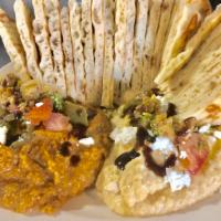 Hummus Envy · 2 flavors of hummus with soft pita topped with olives, goat cheese, peppers, pico, pesto and...
