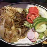 Bistec Encebollado · Steak with caramelized onions. Served with rice, beans and tortillas. 