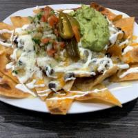 Nachos · Tortilla chips with beans, Monterey Jack cheese topped with guacamole, jalapeños, and pico d...