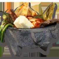 Molcajete · Steak, chickens, chorizo, cactus, avocado, and chives served with rice and beans (on mortal ...