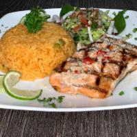Salmon A La Parrilla · Grilled Salmon Served with Salad, rice and beans.