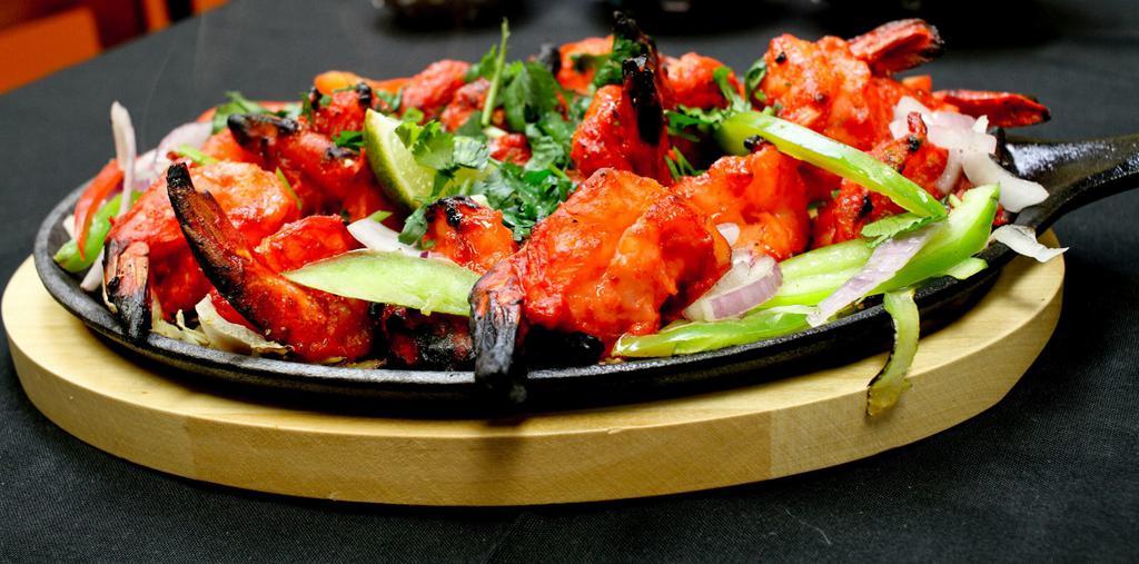 Shrimp Tandoori · Mild, large, mouthwatering shrimp lightly seasoned and slowly broiled over charcoal in tandoori oven, served with rice and dal.