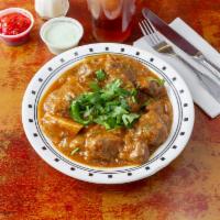 Goat Curry · Pieces of goat gently cooked in a thick sauce.