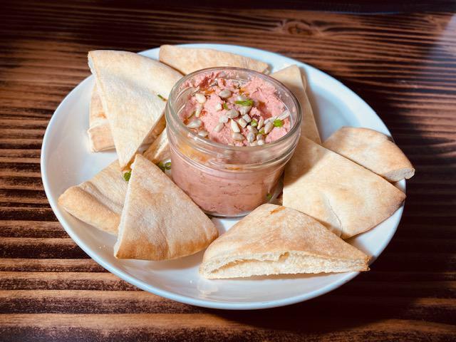 Pink Hummus  · Beetroot, citrus, red chili flakes, sunflower seeds and baked pita chips. 