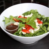 Caprese Salad · Fresh mozzarella, tomatoes, basil, olive oil, and balsamic vinaigrette served on top of lett...