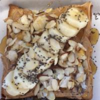 Peanut Butter and Banana Toast · Peanut butter spread topped with sliced bananas drizzled with honey and sliced almonds.