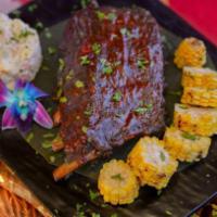 Pork Ribs · Smoked pork ribs served with potato salad & grilled corn

(Costillas de cerdo ahumadas acomp...