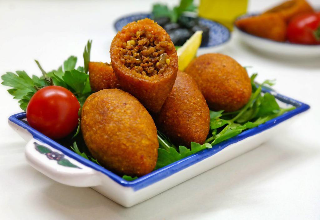 Kibbeh · 2 pieces.  Wheat bulgur stuffed with seasoned ground lamb and pine nuts.