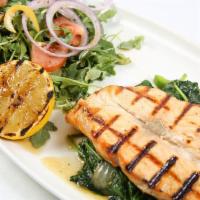 Grilled Salmon · Grilled steak cut salmon, served over a bed of sauteed spinach and arugula salad.