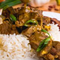 Curried Goat · Tender chunks of curry-clad goat cooked to the bone. Includes potatoes and carrots for a hea...