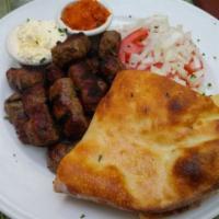 Cevapi · Balkan beef sausages served in fresh baked pita bread.