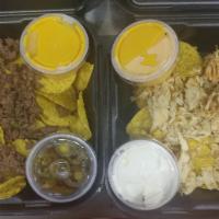 Nachos · Topped with nacho cheese, jalapenos and sour cream.