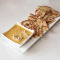 Platha and Coconut Chicken Curry Dip · Handmade multi-layered bread served with coconut chicken curry sauce for dipping.