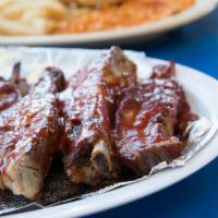 BBQ Ribs Dinner · Choice of 4 or 7 piece ribs covered in BBQ sauce. Served with home-made rice, refried beans,...