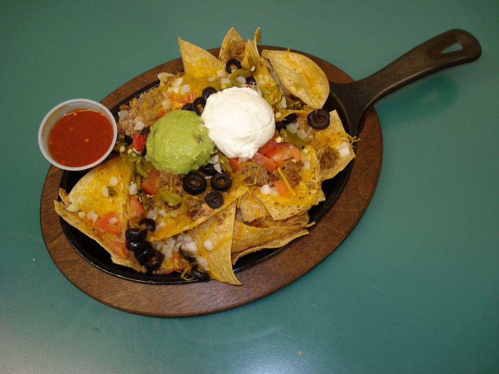 Super Nachos · Fresh tortilla chips, beans, beef, cheese, onions, tomatoes, diced Pueblo chilies, sour cream and guacamole. Served on a skillet.