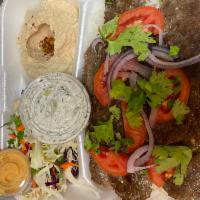 Beef Gyro Plate · Beef gyro served over rice, with sides of hummus, salad, tzatziki, and pita bread.
