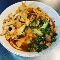 Tortilla Chicken Soup · Large bowl filled with chicken broth, shredded chicken, rice, avocado and pico. Topped with ...