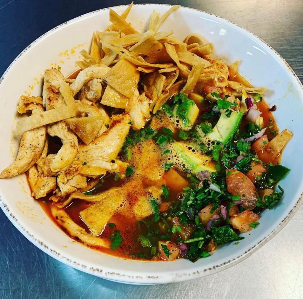 Tortilla Chicken Soup · Large bowl filled with chicken broth, shredded chicken, rice, avocado and pico. Topped with crunchy tortilla strips and cheese.