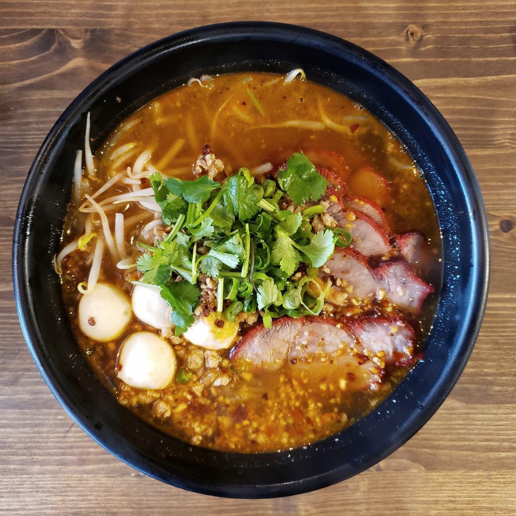 Tom Yum Noodle Soup · Thai style hot and sour soup with rice noodle, roasted pork, home-style ground pork, fish ball, bean sprouts. Sprinkled with ground peanut, scallion, cilantro and crispy fried garlic in spicy tom yum broth. Spicy. Contains nuts.