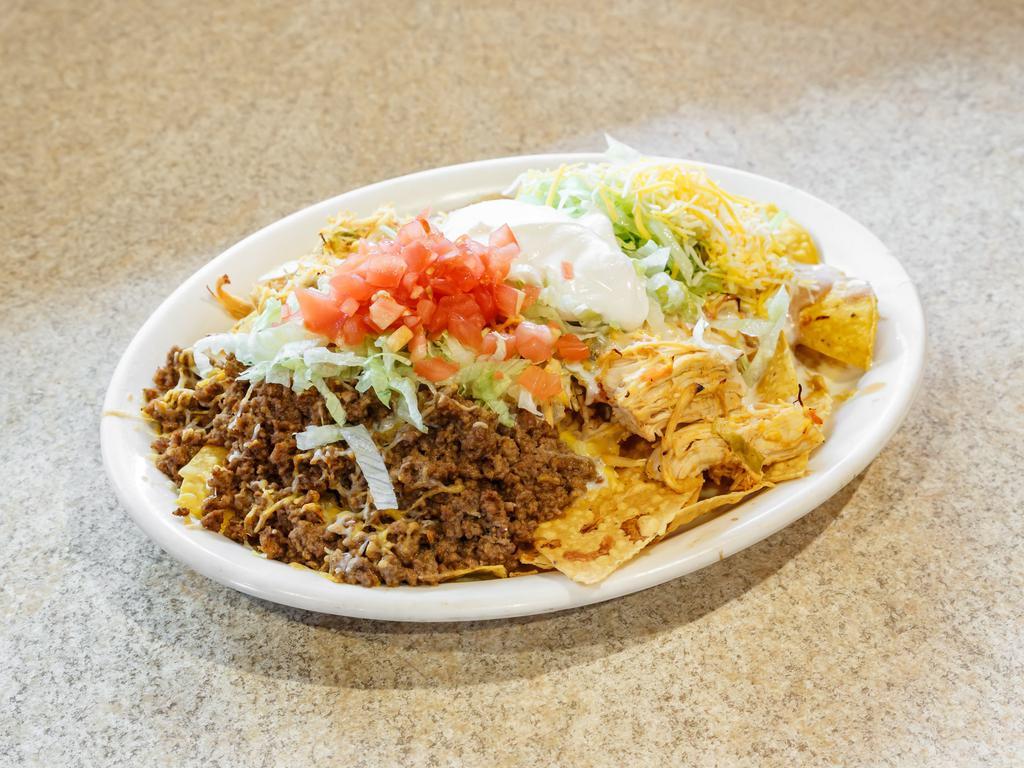 Nachos Supremos · Our cheese nachos covered with beef, chopped chicken, re-fried beans, shredded lettuce, tomatoes and sour cream.