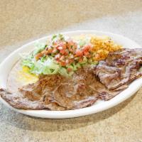 Carne Asada · Thin cut of grilled steak. Served with Mexican rice, re-fried beans, lettuce, guacamole and ...