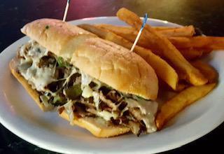 PHILLY CHEESESTEAK  · Thinly sliced sirloin beef or chicken, green peppers, grilled onions, and Swiss cheese on a French roll.