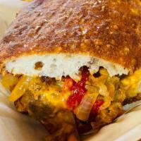 The Kat Panini · Shaved steak, sauteed roasted red peppers, and onions, cheese sauce, and basil mayo on amazi...