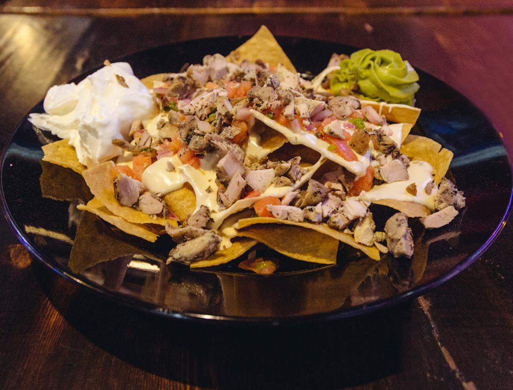 Spiedie Nachos · Tortilla chips topped with marinated chicken, queso, Colby Jack, lettuce, pico
