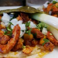 Taco al pastor  · Pork meat marinated in a combination of dried chilies, spices, and pineapple
