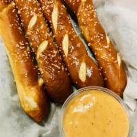 Soft Pretzel Sticks · Warm and buttery pretzels topped with salt, served with warm beer cheese dipping sauce.