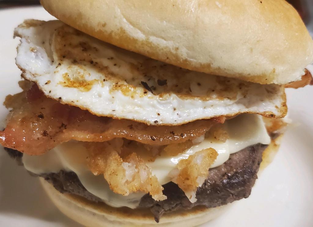 Brunch Burger · 1/2 lb. burger grilled to perfection and then topped with melted american cheese, over easy egg, hash-browns, and bacon. Served with fries.