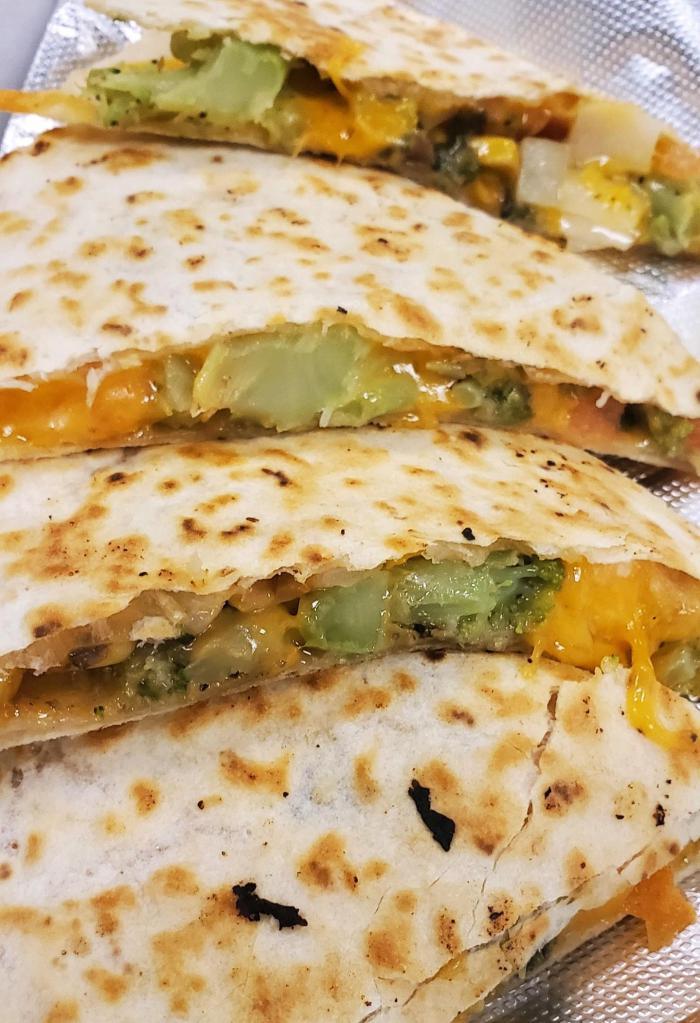 Veggie Quesadilla · Grilled flour tortillas filled with melted cheddar cheese, broccoli, diced tomatoes, onions, corn, black beans and mushrooms. Served with a side of sour cream and salsa.