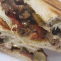 Cajun Steak and Cheese Panini · Shaved top round steak mixed with cajun and tabasco seasoning and then mixed with onions, pe...