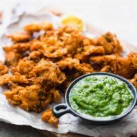 Veggie Pakoras · Two crispy appetizers filled with potatoes, peas, and ginger-garlic. Soft with a crispy crus...