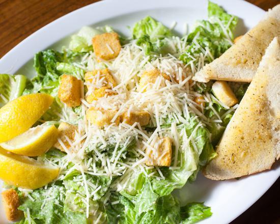 Caesar Salad · Fresh topped romaine lettuce tossed with Parmesan cheese and Caesar dressing served with warm pita bread.