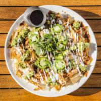 Our Famous Pulled-Chicken Nachos · A favorite! House-made tortilla chips are layered with loads of Oaxaca and white cheddar che...