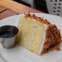 Toasted Coconut Cake · Triple-layer coconut vanilla cake with coconut buttercream and white chocolate shavings. Ser...