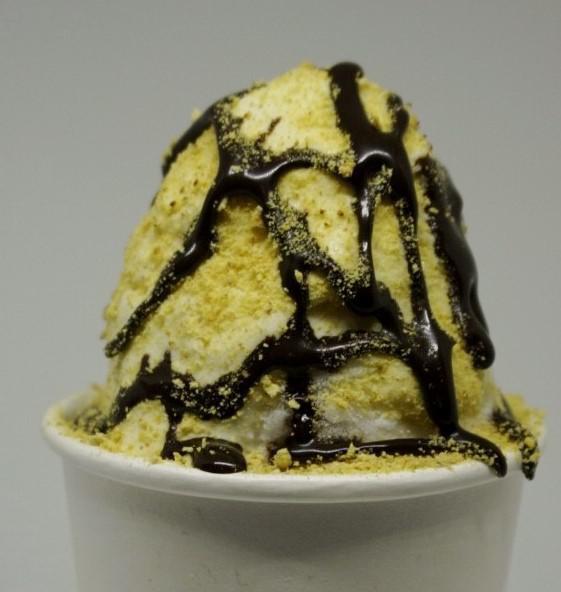 S'mores Shaved Ice · Silver fox shaved ice, a scoop of vanilla ice cream, topped with marshmallow cream, chocolate drizzle, and graham cracker crumbs.