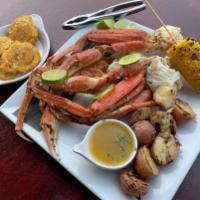 Paths de cangrejo(Snow crab legs) · Snow crab legs in lemon butter garlic sauce, served with corn, roasted potatoes and tostones 