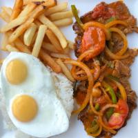 Churrasco Leticias · Sautéed thin steak with bell peppers, tomatoes and onions served with fries, fried eggs over...