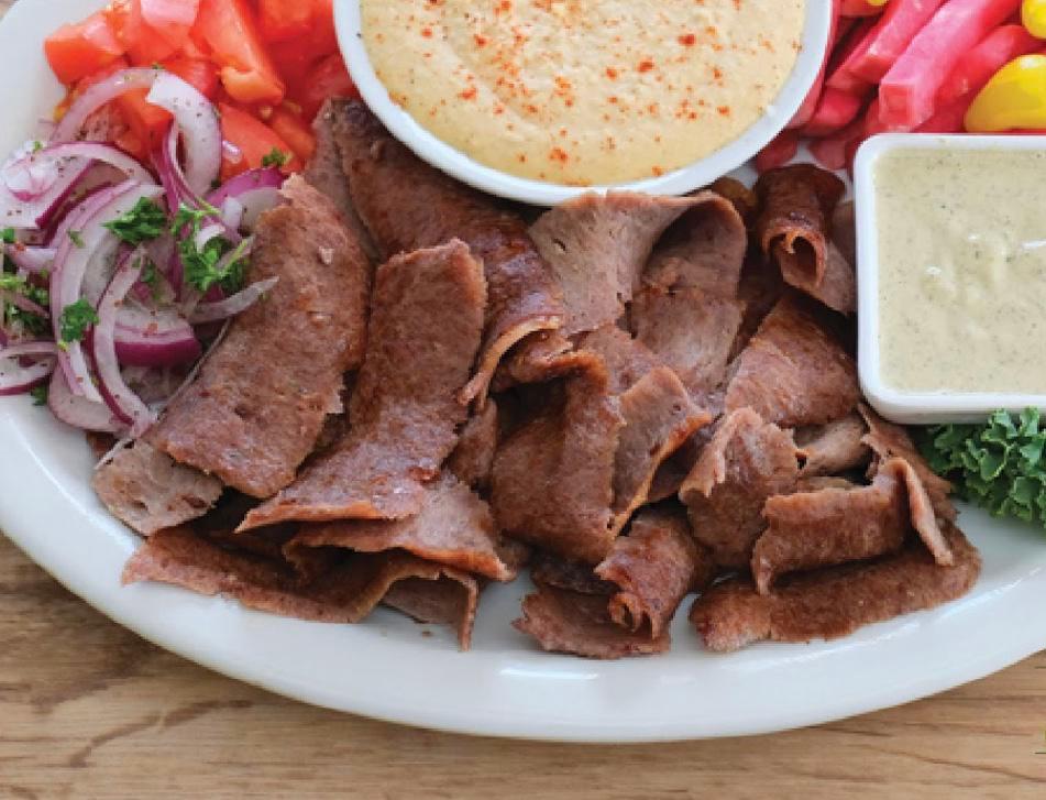 # 7 Beef Shawarma · Slow roasted & thinly shaved marinated Black Angus beef with our house spices, hummus, tahini, onions, tomatoes, pickled turnips, pita bread.

