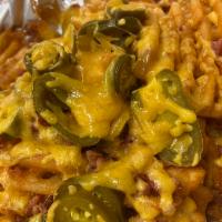 Waffle Explosion  · Waffle fries covered in jalapeño peppers, sprinkled bacon and cheddar cheese with a side of ...