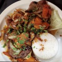Bistek Encebollado · Steak and onions a served with white rice.